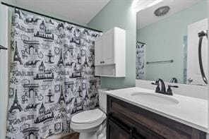 bathroom with vanity, curtained shower, and toilet