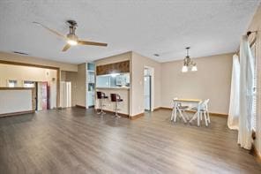 interior space featuring dark wood-type flooring and ceiling fan with notable chandelier