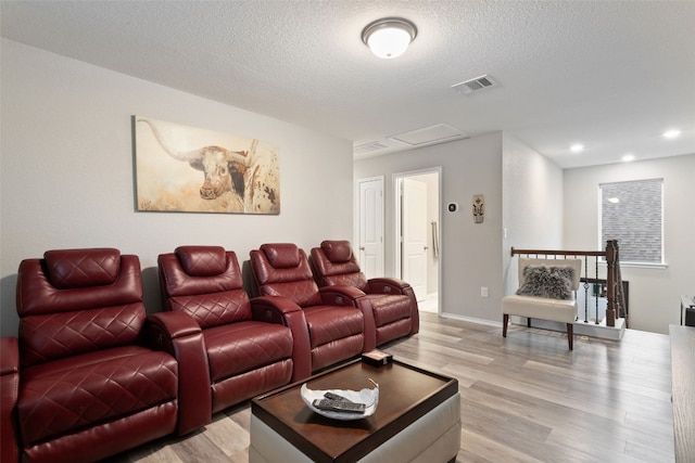 home theater featuring a textured ceiling and light hardwood / wood-style flooring