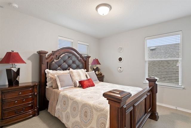 carpeted bedroom featuring multiple windows and a textured ceiling