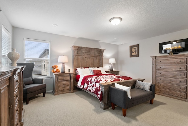 bedroom featuring light carpet and a textured ceiling