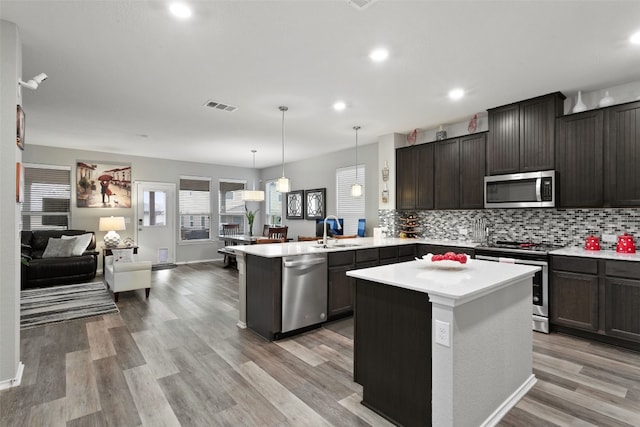 kitchen featuring pendant lighting, tasteful backsplash, appliances with stainless steel finishes, and a kitchen island