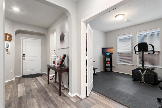 corridor with hardwood / wood-style flooring and a textured ceiling