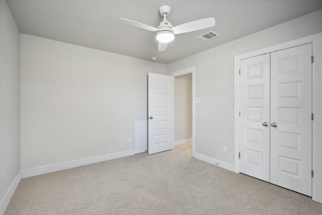 unfurnished bedroom with light colored carpet, a closet, and ceiling fan