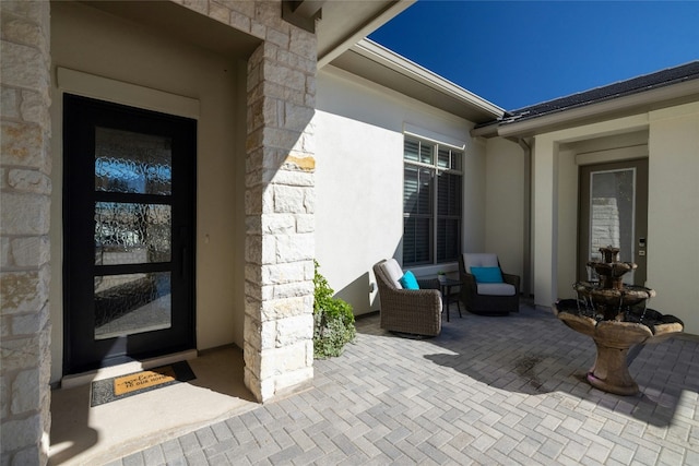 view of exterior entry with a patio area