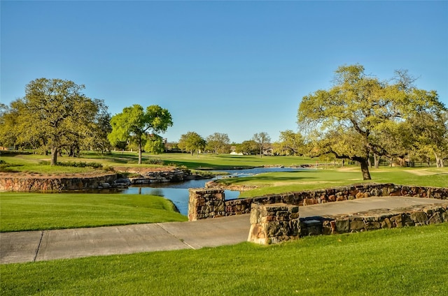 surrounding community featuring a lawn and a water view