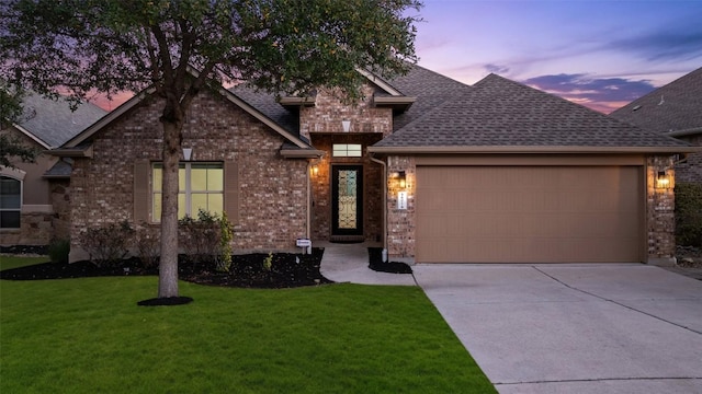 view of front facade with a garage and a yard