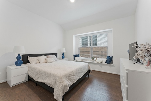 bedroom with dark wood-type flooring and lofted ceiling