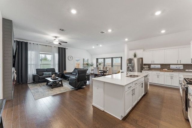 kitchen with white cabinetry, appliances with stainless steel finishes, sink, and a center island with sink