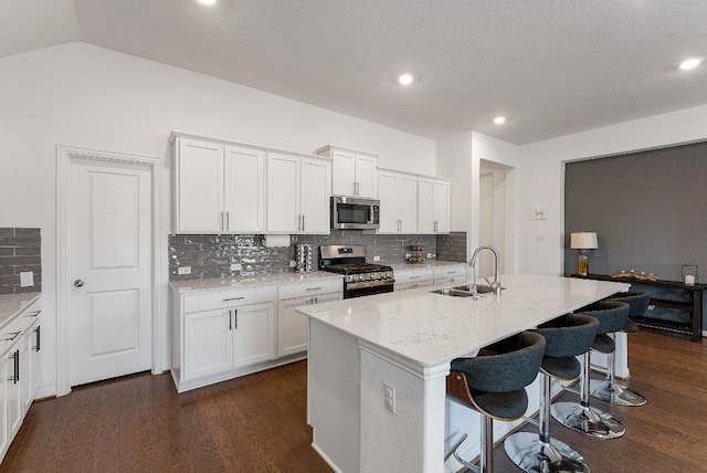 kitchen featuring appliances with stainless steel finishes, sink, and a kitchen island with sink