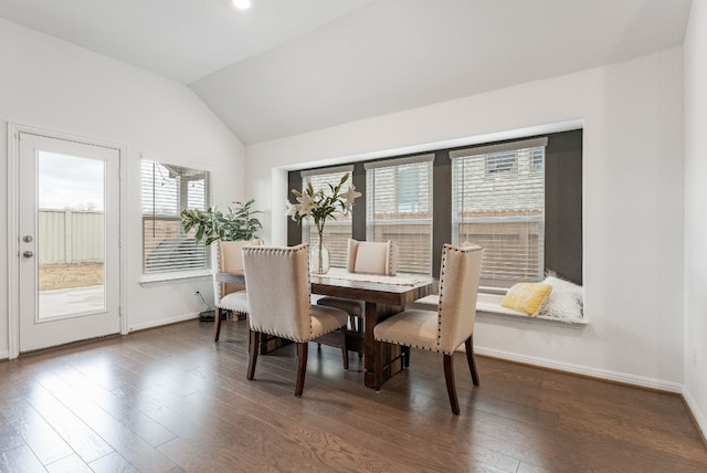 dining space with dark hardwood / wood-style flooring and vaulted ceiling