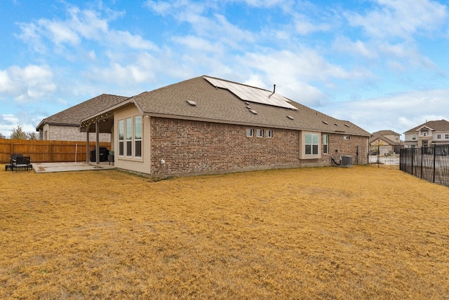 rear view of house featuring a yard, cooling unit, and a patio area