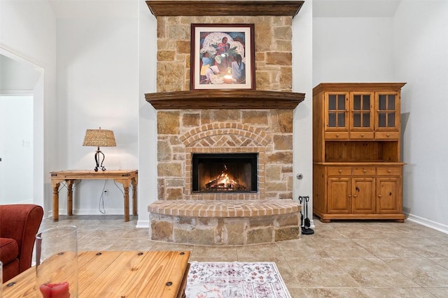 sitting room with light tile patterned flooring and a stone fireplace