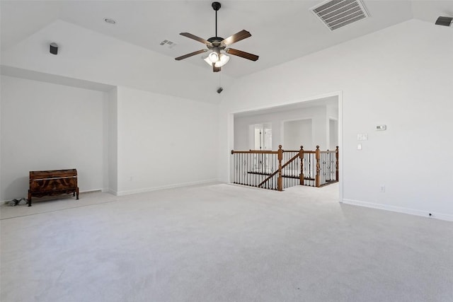 empty room featuring ceiling fan, vaulted ceiling, and light carpet