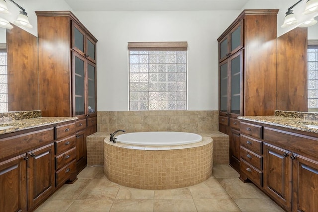 bathroom with vanity, tile patterned floors, and tiled bath