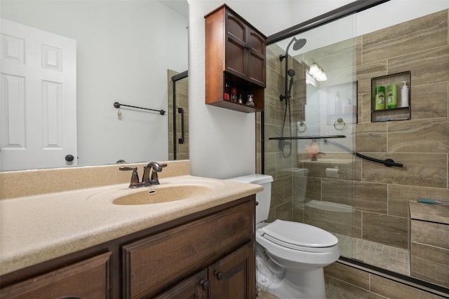 bathroom with an enclosed shower, vanity, and toilet