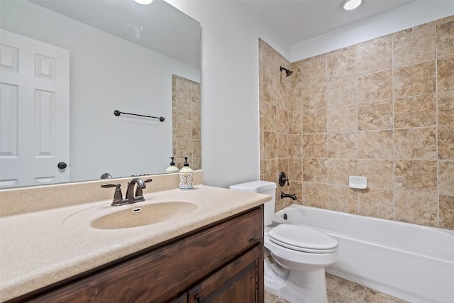 full bathroom featuring tiled shower / bath, vanity, and toilet