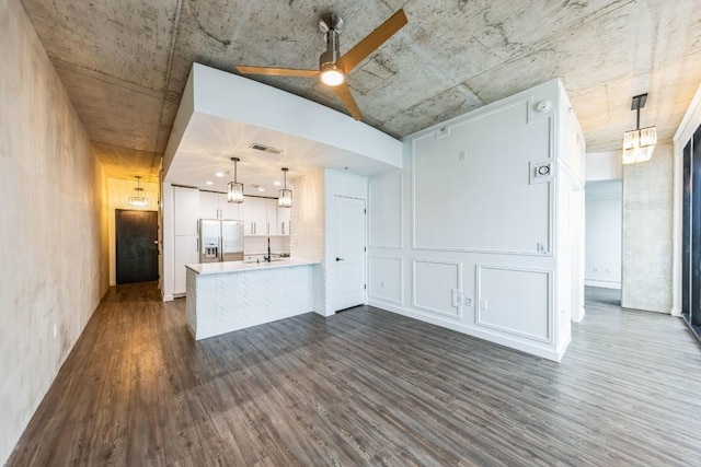 unfurnished living room featuring dark wood-type flooring, ceiling fan, and sink