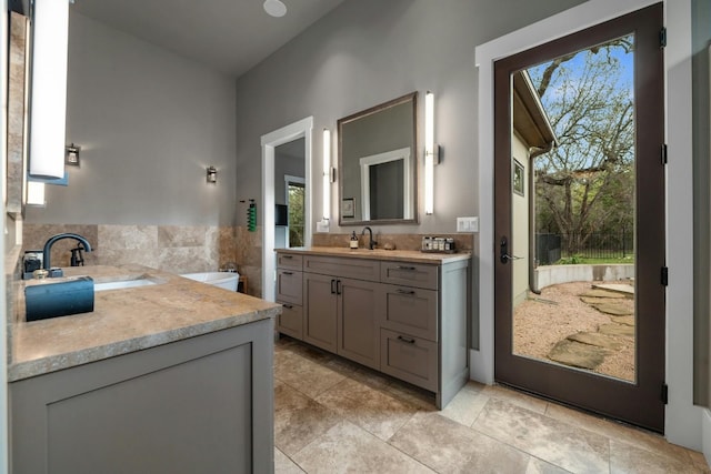 bathroom with two vanities, a sink, and a wealth of natural light