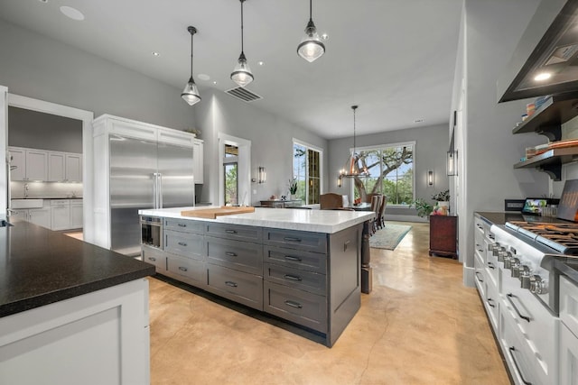 kitchen featuring visible vents, a kitchen island, appliances with stainless steel finishes, gray cabinets, and concrete flooring