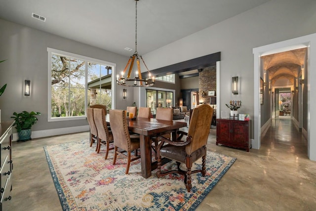 dining space with finished concrete flooring, an inviting chandelier, baseboards, and visible vents