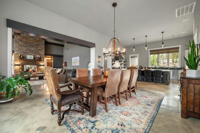 dining space with finished concrete flooring, an inviting chandelier, visible vents, and recessed lighting