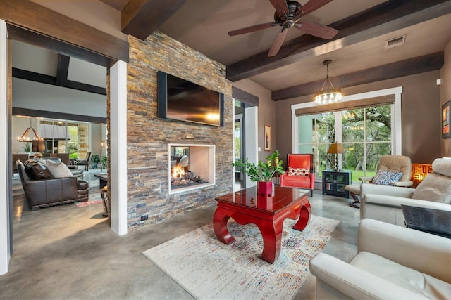 living area featuring finished concrete flooring, beamed ceiling, an outdoor stone fireplace, and visible vents