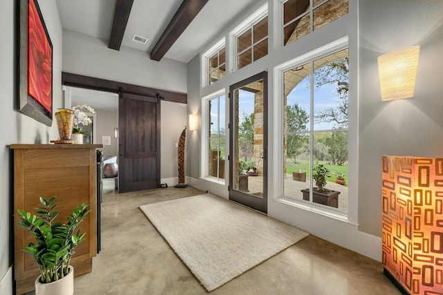 doorway to outside featuring concrete flooring, beam ceiling, and a barn door