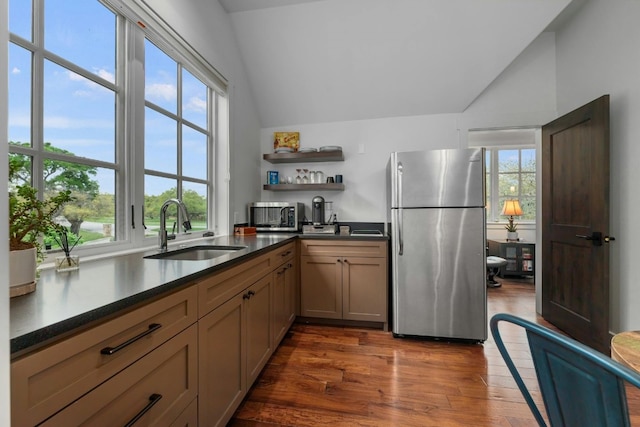 kitchen with open shelves, stainless steel appliances, a sink, and lofted ceiling