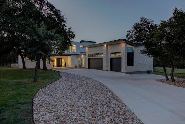 contemporary home with a garage and a yard