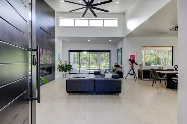 living room featuring a large fireplace, a wealth of natural light, and light wood-type flooring