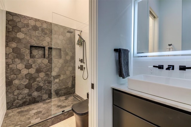 bathroom with toilet, a tile shower, and backsplash