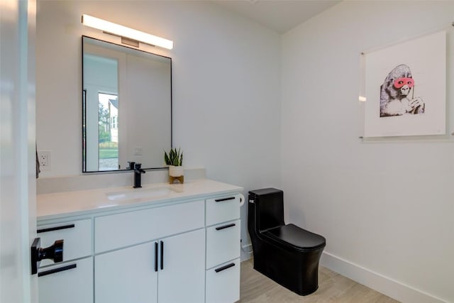 bathroom featuring vanity, hardwood / wood-style floors, and toilet