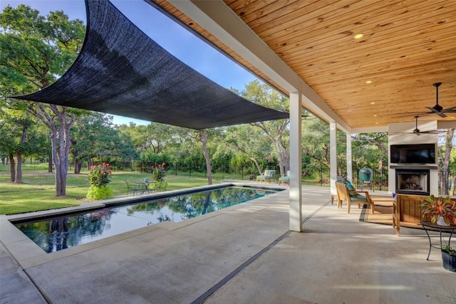 view of pool featuring ceiling fan, exterior fireplace, and a patio