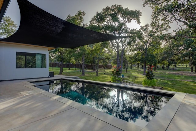 view of swimming pool featuring a patio and a lawn