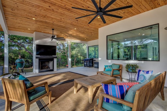 view of patio with an outdoor living space with a fireplace and ceiling fan