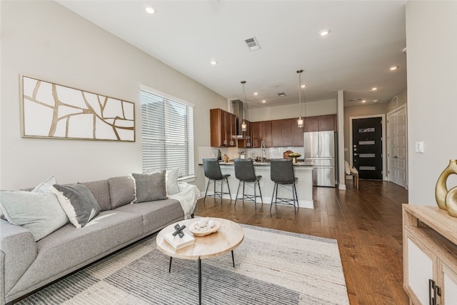 living room featuring sink and dark wood-type flooring