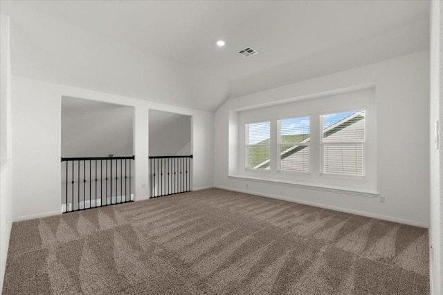 carpeted spare room with vaulted ceiling