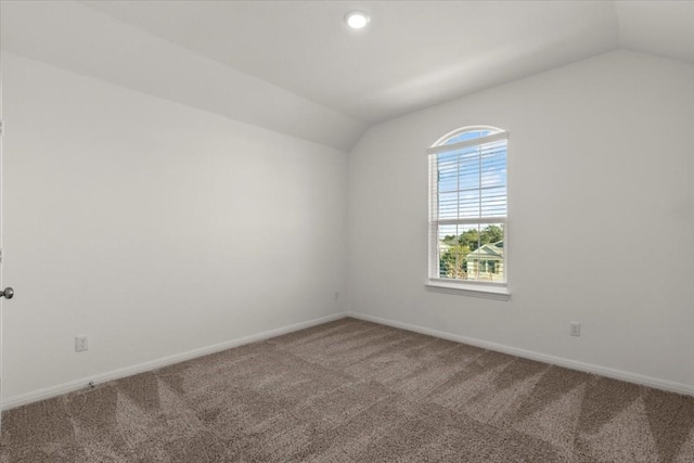 unfurnished room with carpet floors and vaulted ceiling