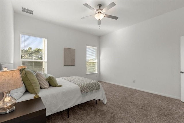 bedroom featuring ceiling fan, carpet floors, and multiple windows