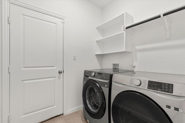 laundry room featuring washer and clothes dryer and light tile patterned floors