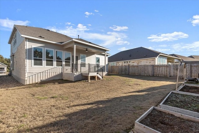 back of property featuring a yard and ceiling fan