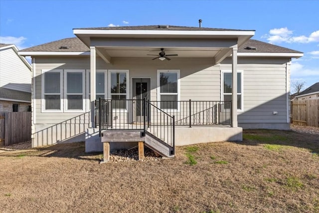 back of property with ceiling fan and a lawn