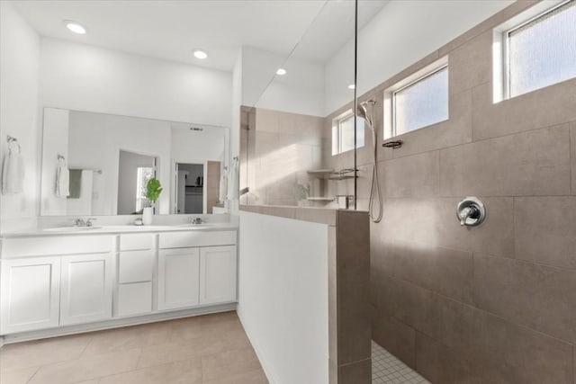 bathroom featuring vanity, tile patterned flooring, and a tile shower