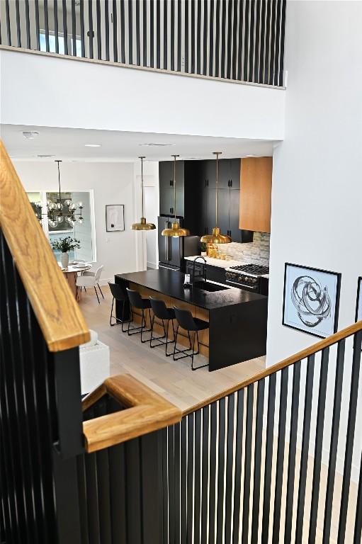 bar featuring tasteful backsplash, gas stove, sink, and a high ceiling