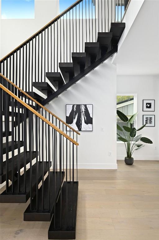 staircase with hardwood / wood-style floors and a high ceiling