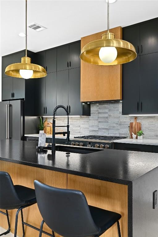 kitchen featuring hanging light fixtures, a breakfast bar, and high end refrigerator