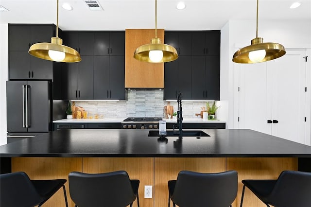 kitchen with high quality fridge, range, a kitchen breakfast bar, and hanging light fixtures