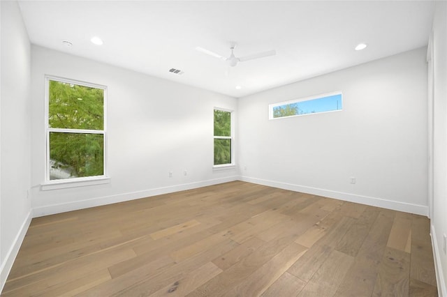 empty room with ceiling fan and light hardwood / wood-style floors