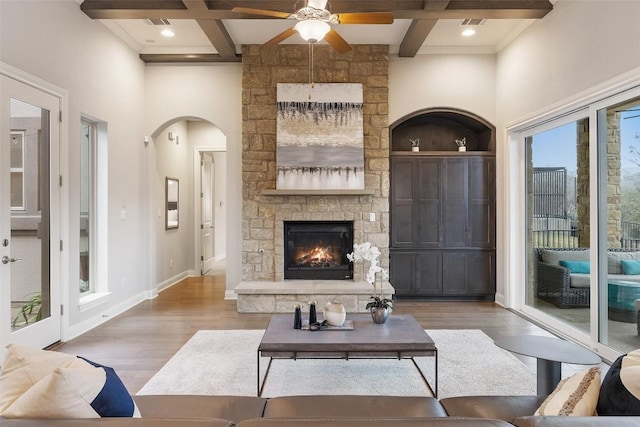 living room featuring hardwood / wood-style flooring, a fireplace, coffered ceiling, and beamed ceiling